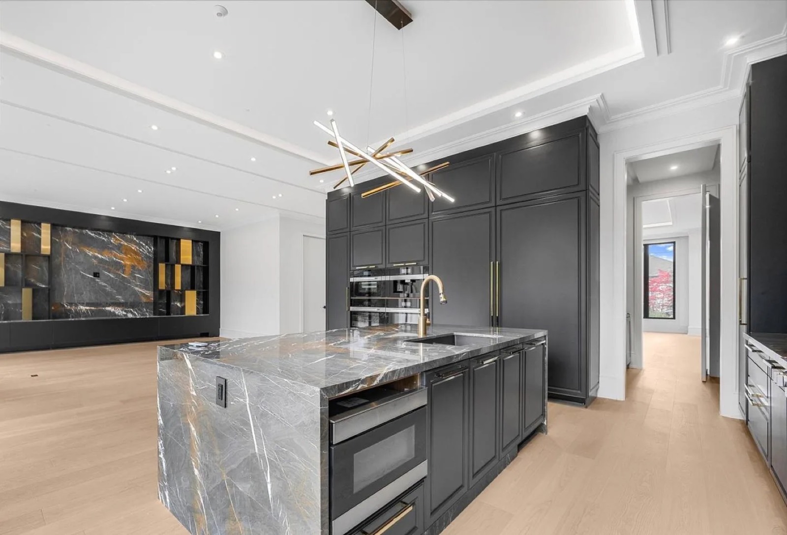 Finished kitchen with a waterfall stone island and custom cabinetry