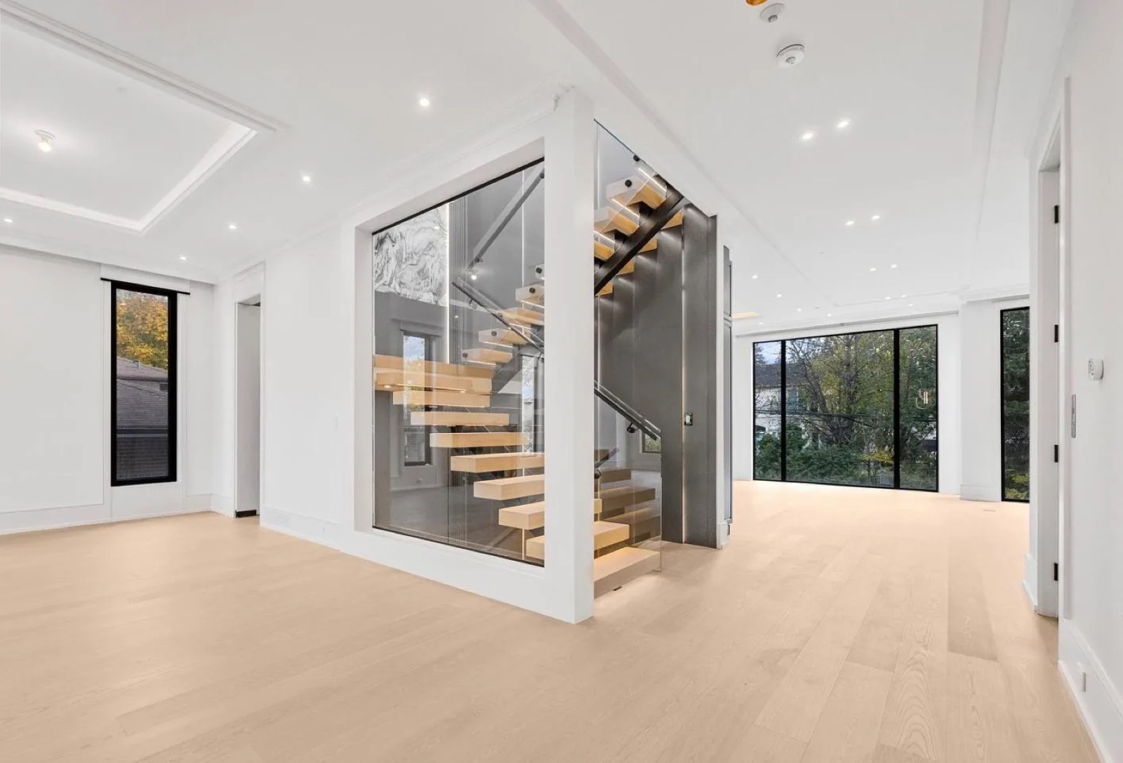 Open-riser oak staircase and wide plank floors after renovation
